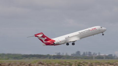 Sydney, Australia - Mar 26, 2022: Tracking shot of QantasLink airplane taking off at Sydney airport