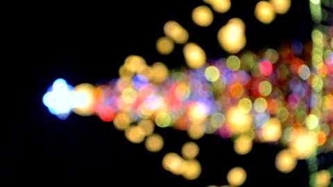 New Year's Christmas tree decorated with luminous multi-colored garlands and illumination at night. Christmas tree with flashing lights. Blurred background. New Year Christmas holidays. Vertical video
