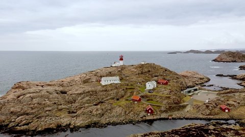 lindesnes , agder , Norway - 03 05 2022: Beautiful slow rotating overview of Lindesnes lighthouse and museum in southern Norway - Cloudy day with North Sea in background