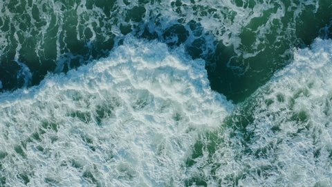 Top view of stormy sea wave close up texture. Powerful stormy sea ocean waves top-down view drone shot.  Aerial View Of of Clear turquoise sea Aqua sea water surface in 4K