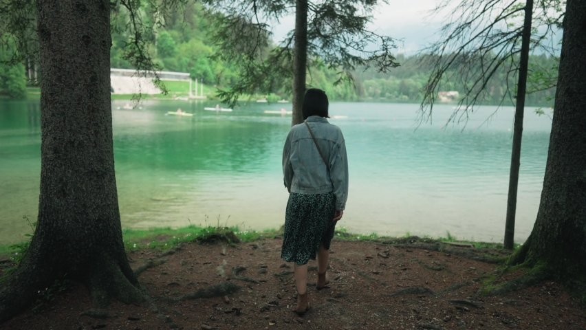Female tourist enjoying walking in nature next to beautiful lake. Young woman in national park nature