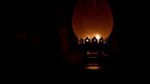 A kerosene lamp burns in the dark