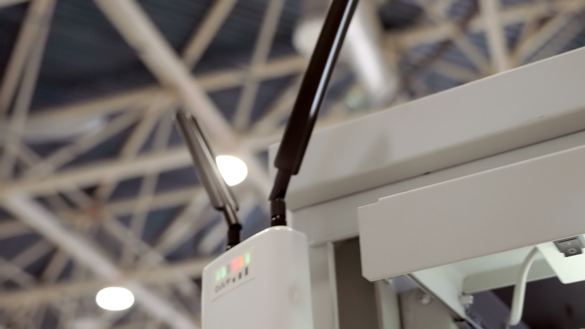 A powerful wi-fi router with two antennas works in a large hall and distributes the Internet and the signal lights flash. Closeup. Shot in motion Royalty-Free Stock Footage #1090862675