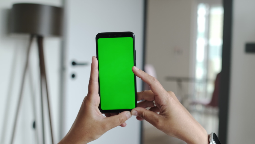 Green Mock-up Screen Chroma Key, Mock-up Screen on Mobile Phone. Scrolling, Sliding, Swiping Internet Online, Browsing Media. Closeup Point of View Footage. Cozy Apartment on Background.  Royalty-Free Stock Footage #1090865981