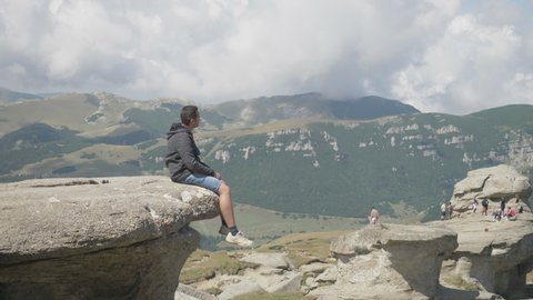 Man sit on mountain peak admiring amazing panorama