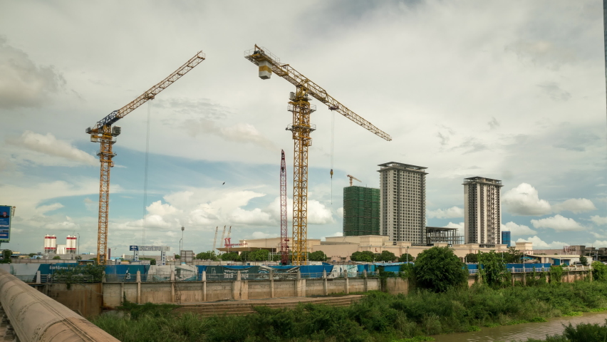 Cranes in construction site, Phnom Pen, a rapidly changing city sky scape with Chinese belt road initiative investment, high rises. Time lapse of progress in Cambodia. Royalty-Free Stock Footage #1090870867