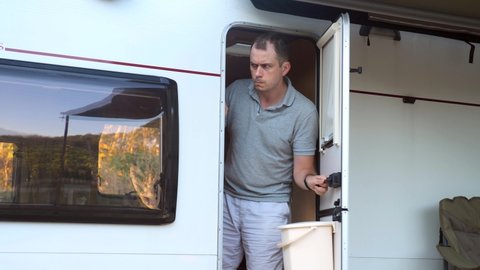 Suspicious, skeptic and confused man in camping van. Conspiracy theory, paranoia, suspicion concept. Curious or paranoid person looking out from door. Mistrustful and nervous guy. Persecutory delusion