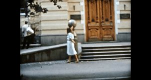 Woman walking on 80s Europe city street in summer. Person looking landmarks, old buildings in sun day. Travel attraction, urban view. Vintage color film. Cityscape archive. Retro 1980s Kyiv Ukraine