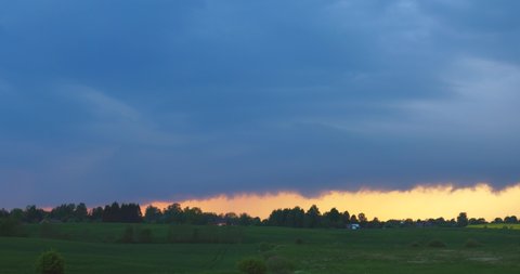 Storm clouds over fields. Long shelf cloud across the horizon
