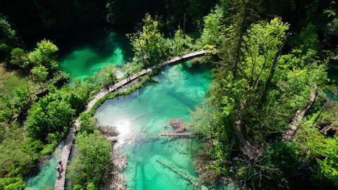 Aerial Overhead View Of Wooden Boardwalk Across Plitvice Lakes And Waterfalls in National Park in Croatia. Tracking Shot.