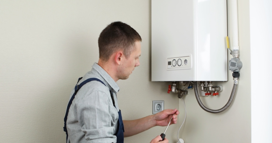 Plumber attaches Trying To Fix the Problem with the Residential Heating Equipment. Repair of a gas boiler. Royalty-Free Stock Footage #1090874855