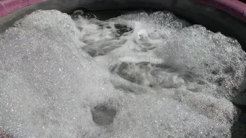A Round Outdoor Hot Tub Bubbling with its Jets Blowing. 
