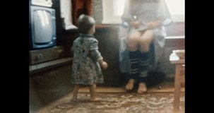 Happy mother and child play together in apartment. Smiling child plays with mother. Happy family in Soviet apartment building. Family life indoors. Vintage color film. Family archive. Retro 1980s. 4k