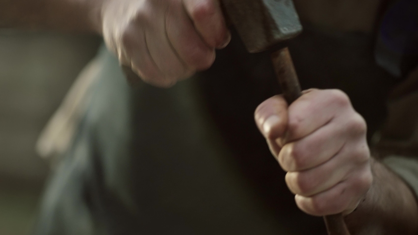 Sculptor shaping a big stone. Rock breaking. Stone carving. Changing tools.