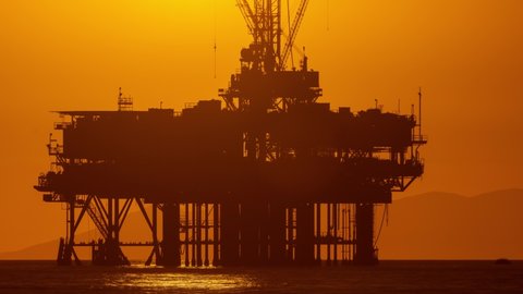 Time lapse of the sun setting behind an offshore oil platform off the coast of California