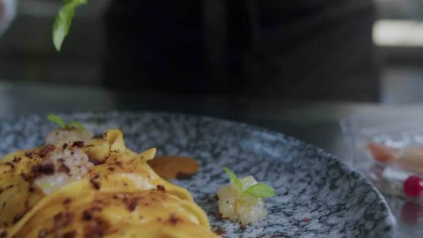 A professional chef in Italy is prepairing a plate of pasta and scampi in his kitchen - 01