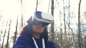 4K video clip of beautiful girl teenager female young woman using virtual reality VR headset in a forest woodland environment