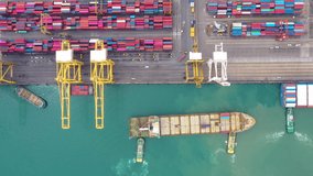 Aerial top view tugboat drag container ship in commercial shipping port footage 4k video from drone camera