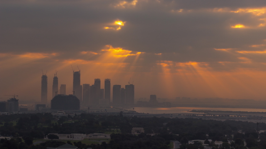 Sunrise over Dubai Creek Harbor with skyscrapers and towers under construction aerial timelapse. Cloudy orange sky with sun beams | Shutterstock HD Video #1090908727