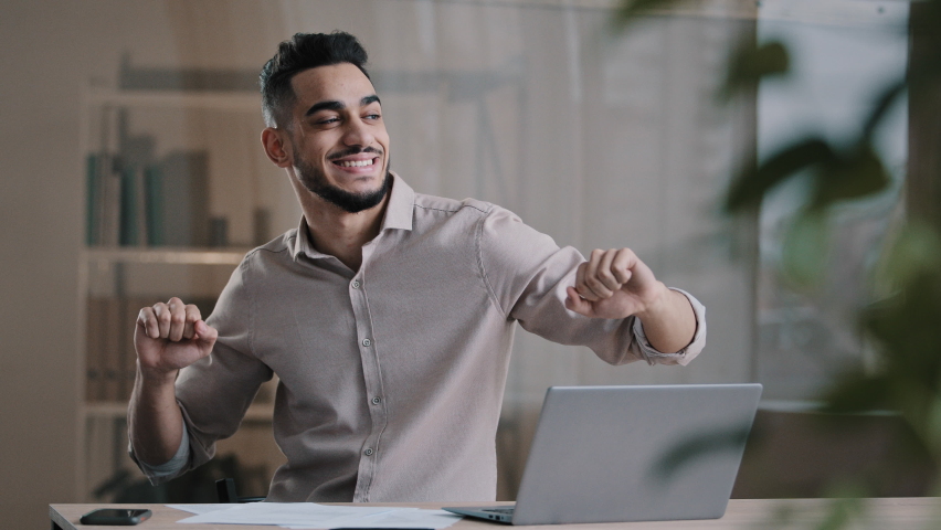 Happy funny male arabic businessman hispanic young guy millennial smiling man active dancing at home office has fun celebrate end of working enjoy exercises movement sing favorite song take job pause Royalty-Free Stock Footage #1090910777