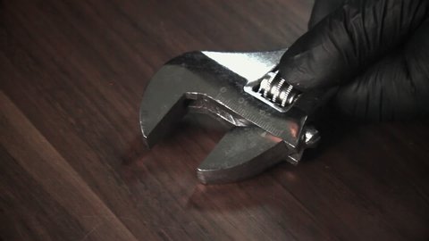 Mechanic demonstrates how to use a wrench. Tool and fingers of the master close-up