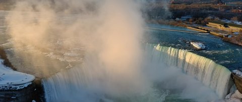This video shows scenic aerial views of the Niagara River and Niagara Falls in Upstate New York and Ontario Canada during sunrise. 