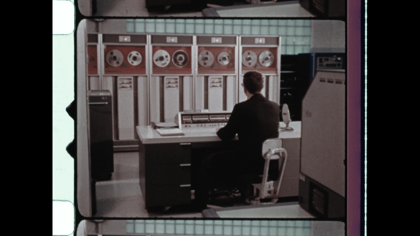 1972 Birmingham, UK. View of the interior of the room housing the Burroughs B2800 mainframe computer at Lloyds Bank Computer Institute. Man operates vintage computer. 4K Overscan of Archival Film