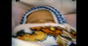 Newborn baby sleeps in stroller, close-up. Cute newborn child sleeping, lies. Vintage color film. Family life. Vintage color film. Sentimental archive. Retro 1980s. Archival nostalgia memories