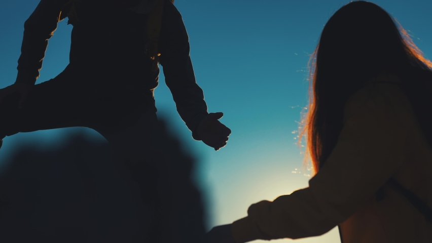 help team concept. couple team silhouette of two climber stretching a helping hand to a friend. business teamwork success concept. silhouette business travel tourists pull a helping hand sunlight Royalty-Free Stock Footage #1090924273