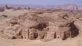 Hegra. Al Ula, Saudi Arabia. High quality aerial drone video. Nabatean tombs in the Unesco World Heritage site, sand, rocks and mountains that are now a tourims destination.