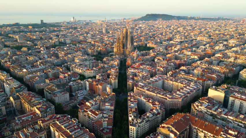 Aerial view of Barcelona Eixample residential district and famous Basilica Sagrada Familia at sunrise. Catalonia, Spain Royalty-Free Stock Footage #1090929645