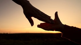 Mom and child holding hands together on sunset background. Silhouette as son or daughter takes mother hand. Sun flares. Family, trust, love and happiness concept - Powered by Shutterstock - Get 15% off with code: PIKWIZARD15