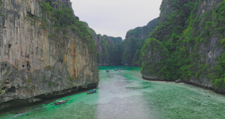Aerial view of Phi Phi islands Travel Landmark of Krabi, Thailand. Drone POV fly over tropical turquoise water Pileh Lagoon surrounded by limestone cliffs. Tourist attraction in summer holidays.