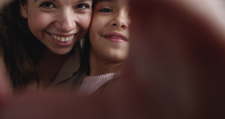 Close up portrait young woman and adorable little 6s daughter joining fingers making heart gesture look at camera feels overjoyed. Symbol of love, life value, cherish, happy motherhood, family concept Royalty-Free Stock Footage #1090941627
