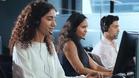 Young modern smiling Indian Asian male and female or mixed gender busy call center employees wearing headsets or headphones interacting with clients in corporate office. Customer care support concept - Powered by Shutterstock - Get 15% off with code: PIKWIZARD15