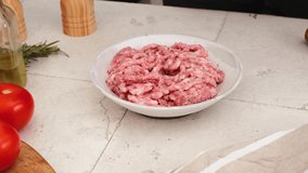 Man hand puts rosemary into the raw minced meat. Cooking food concept. 4k video