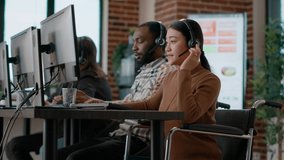 Young woman working at customer assistance service, using microphone on headphones. Female worker talking to clients at call center, helping with remote telemarketing problems. Handheld shot. people - Powered by Shutterstock - Get 15% off with code: PIKWIZARD15
