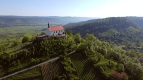 Aerial footage of circling around chapel (Wurmlinger Kapelle) on a hill in Southern Germany in the morning light