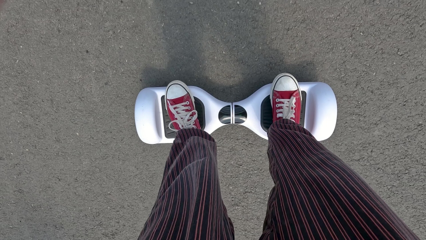 Young person riding hoverboard or electric self balancing scooter 4k. First person view POV