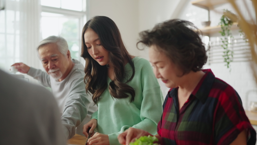 Group of asian elder senior friends at dinner party at home, senior friend preparing salad and fruit juice with her daughter with smiling cheerful moment conversation with elder friend laugh smile Royalty-Free Stock Footage #1090949961