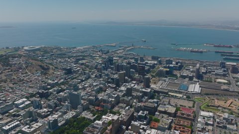 High angle view of city on sea coast. Tall buildings in city centre, train station and harbour. Cape Town, South Africa