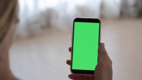 Girl scrolling left and right smartphone with green screen display