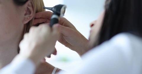 ENT diagnosis and examination of the ear with otoscope of woman