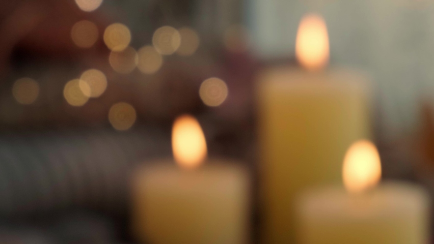 Defocused background Thanksgiving and Hello Fall Hygge atmosphere Autumn leaves and candle on cozy knitted sweater in warm yellow lights | Shutterstock HD Video #1090963061