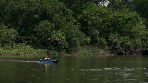 Pasadena, TX, US - June 05, 2022: Male Kayaker paddles quickly into the boat ramp on Armand Bayou in Pasadena Texas.