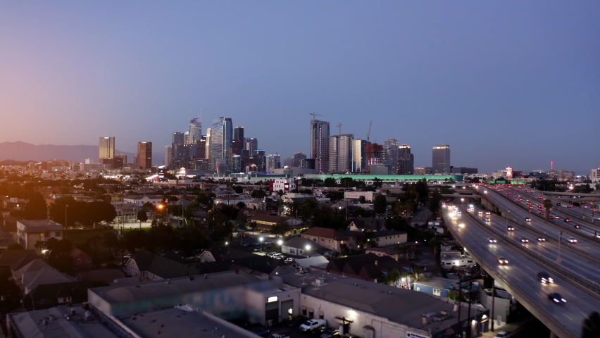 Aerial establishing shot of Los Angeles. Dark sky as traffic flows on highway. Downtown Los Angeles aerial view, business centre Cinematic aerial drone footage of downtown urban LA.  Drone. 4K.  Royalty-Free Stock Footage #1090966223