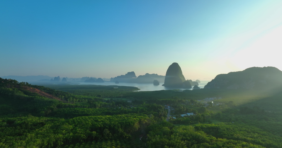 Aerial view of Phang Nga bay national park in Krabi, Thailand. Stunning tropical landscape show line of water with mangroves forest along the sides and clear blue sky. Drone shot over the Bay. Royalty-Free Stock Footage #1090979003