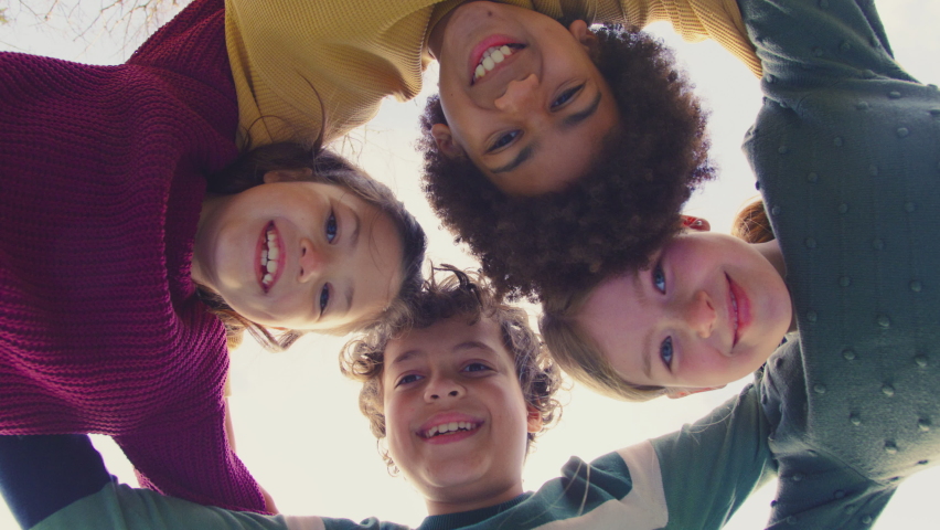 Low angle portrait of children having fun playing outdoors linking arms looking down into camera - shot in slow motion Royalty-Free Stock Footage #1090980285