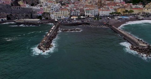 Aerial reveal of gorgeous coastal town in rugged cliffside setting, Amalfi