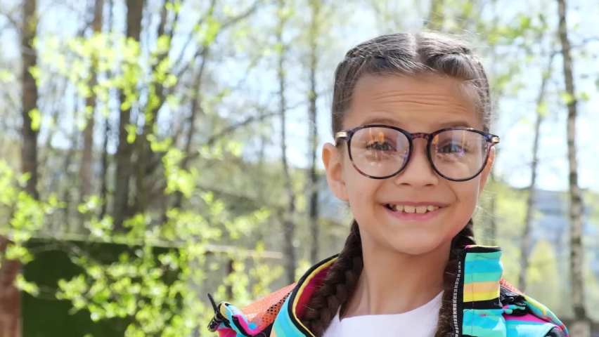 Portrait of cute teen girl with eye glasses outdoors, girl showing thumbs up gesture, kid happy with glasses ,spring weather, cute kid in trendy glasses | Shutterstock HD Video #1090990081